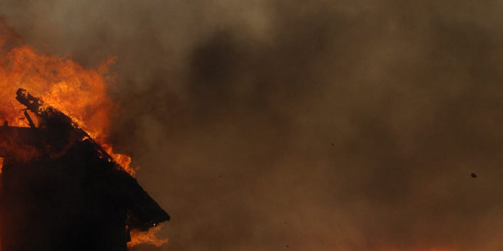 Lit Up Within. Photo by Jen Theodore on Unsplash. Shows the corner of a burning building.
