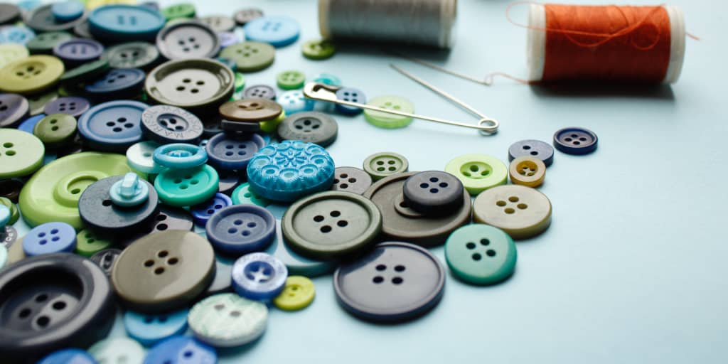 First Home. Photo by Merve Sehirli Nasir on Unsplash. Shows spilled buttons and sewing thread.