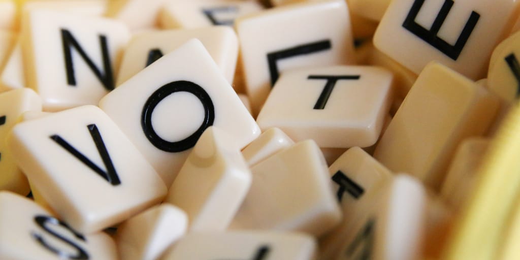 The Air Axe. Photo by Glen Carrie on Unsplash. Shows scrabble pieces spelling out the word 'vote'. Photo by Glen Carrie on Unsplash