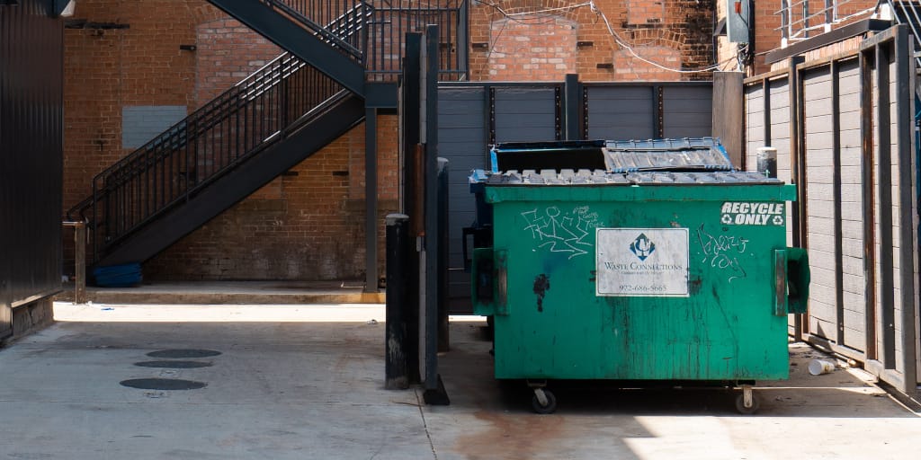 We Appreciate Your Donations. Photo by Jake Heidecker on Unsplash. Shows a green dumpster.