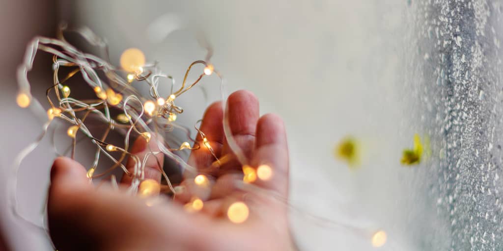 Prepared_Photo by Anshu A on Unsplash. Shows a hand holding trailing fairy lights.