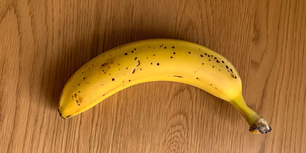 Events as They Unfold in Real Time_Photo by Surendran MP on Unsplash. Shows a banana on a wooden background.