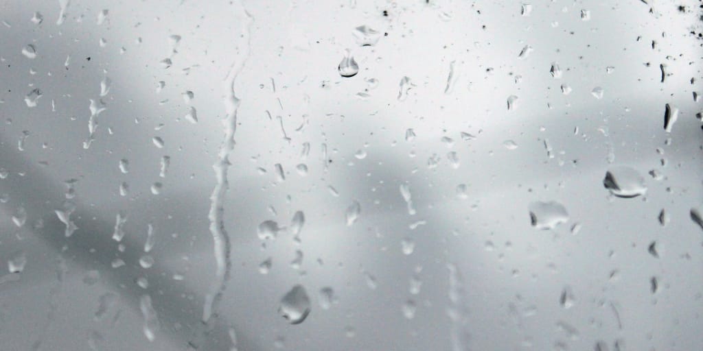 Someday_Photo by Anna Nesterova on Unsplash. Shows raindrops on a window.